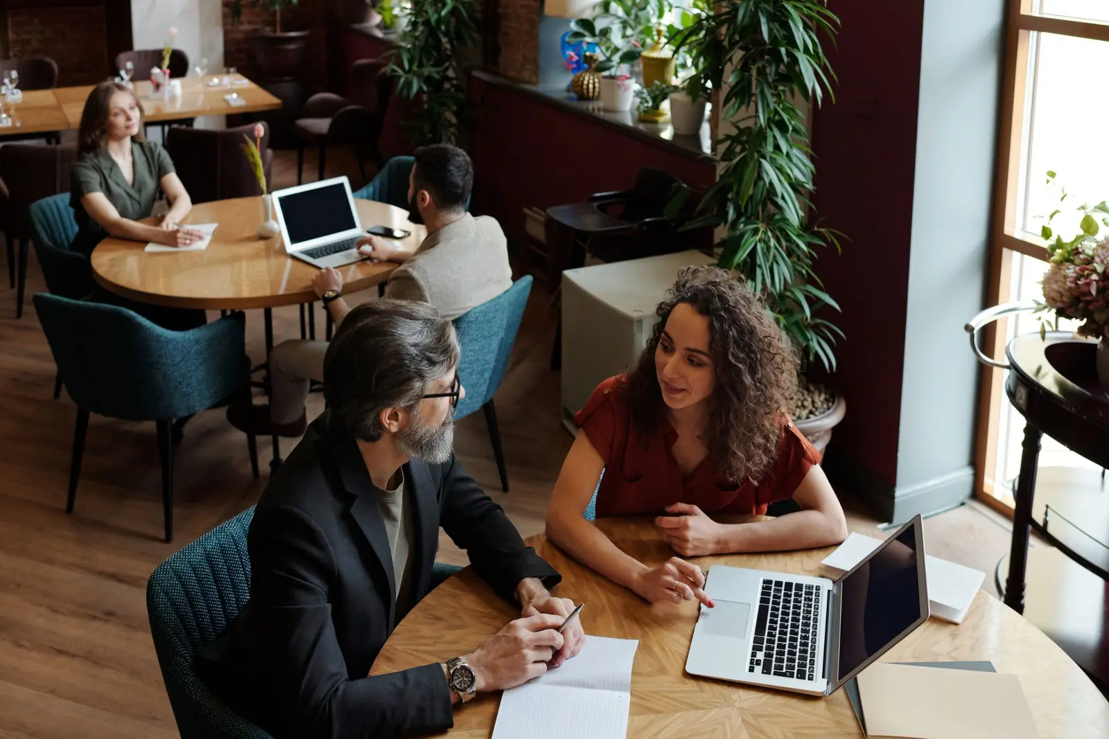 Two people reviewing guest feedback together at a cafe table.